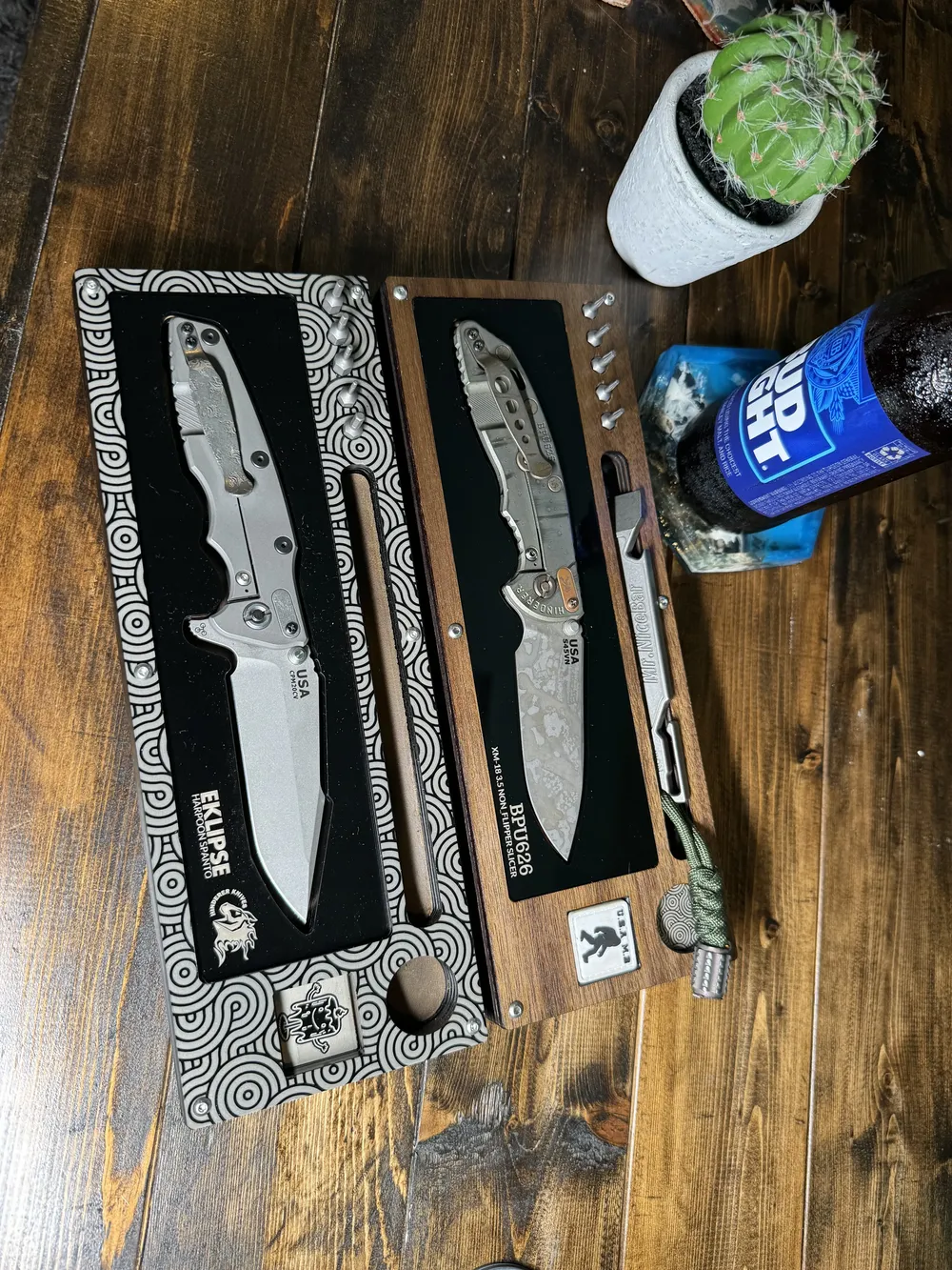 Two Layer Cakes side by side on a plank floor, an Eklipse in the patterned tray and a BPU626 in walnut, with a cactus and a cold one