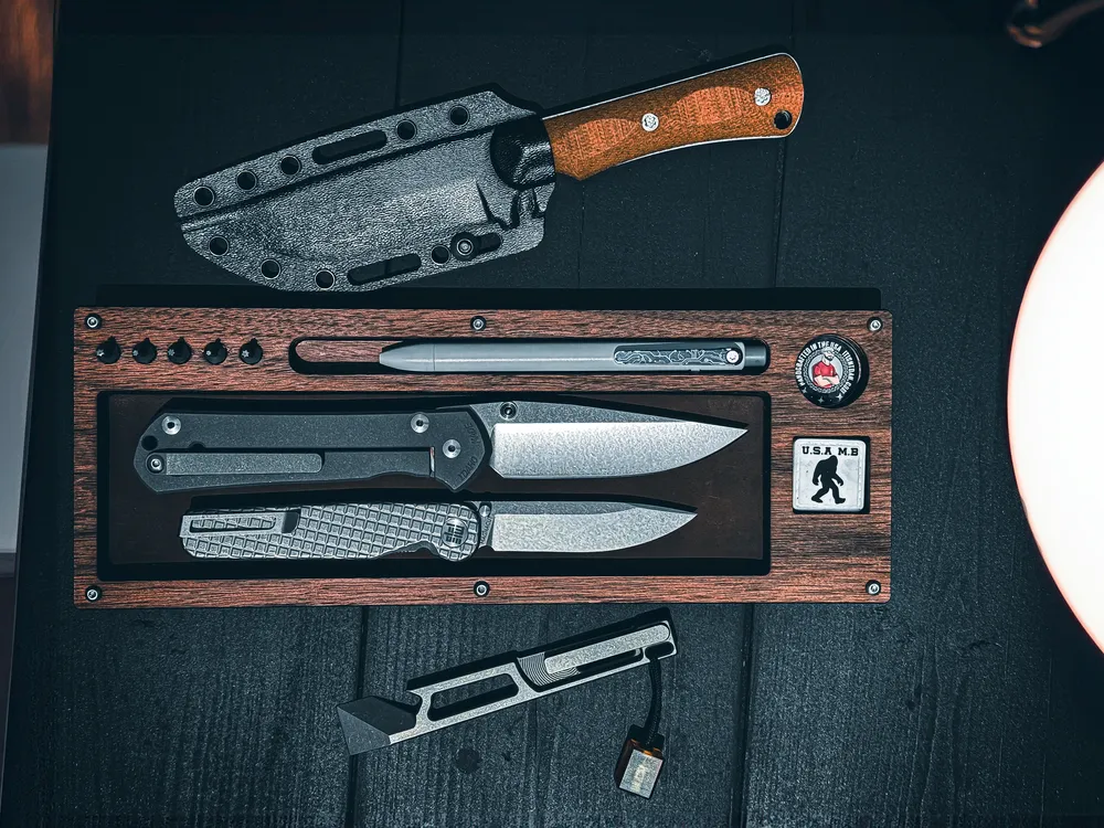Walnut Layer Cake with a folder and slim blade, a kydex sheathed fixed blade above