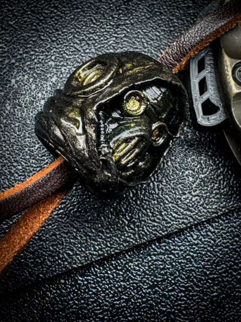 Macro of a robot bead on a leather lanyard