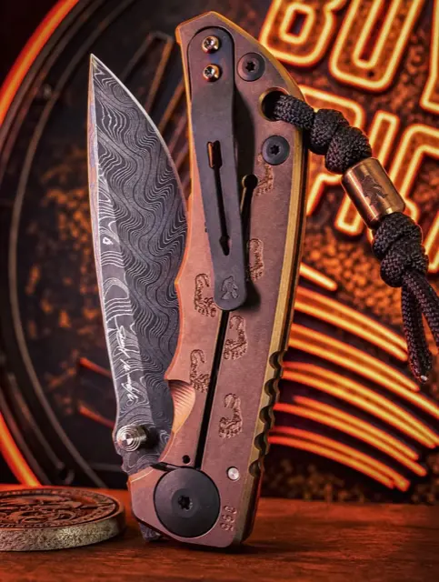Copper damascus folder in front of neon light