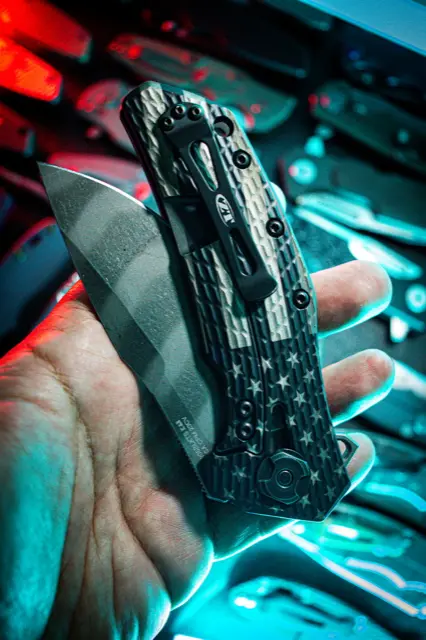 Carbon fiber folder held up in neon light