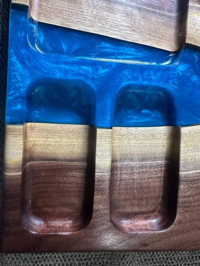 Close up of carved pockets in blue resin and walnut