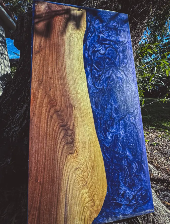 Raw walnut and blue resin slab before carving